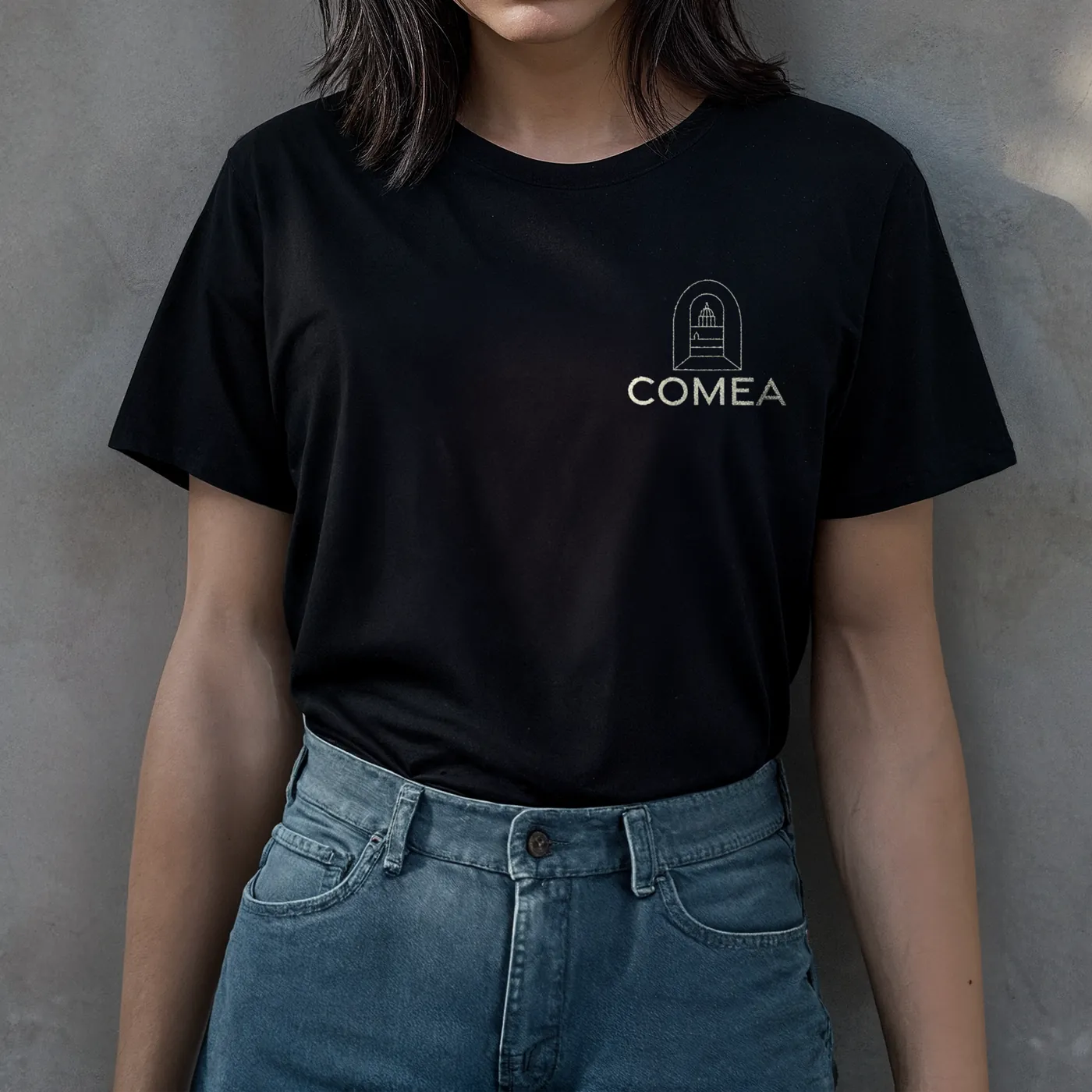Logo COMEA imprimé sur un t-shirt noir, version monochrome